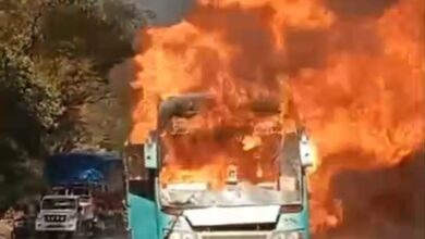 नेवरी फाटा टोल के पास जलती हुई यात्री बस, जिसमें आग की तेज लपटें उठती दिखाई दे रही हैं।