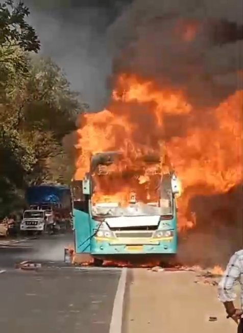 नेवरी फाटा टोल के पास जलती हुई यात्री बस, जिसमें आग की तेज लपटें उठती दिखाई दे रही हैं।