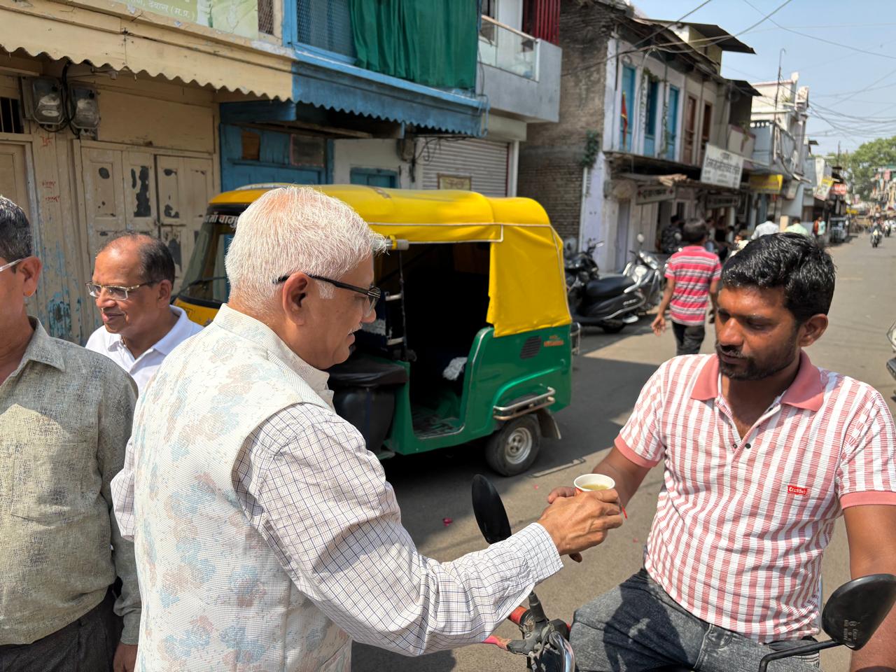 Dr. Pramod Jain distributing sugarcane juice to a passerby on Akshaya Tritiya in Dewas