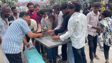 टंट्या भील चौराहे पर राहगीरों को पानी की बोतल वितरित करते संगठन के सदस्य।